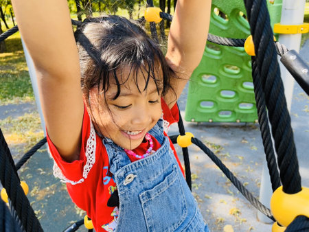 Asian Chinese little girl having fun on the playground in the park.の写真素材