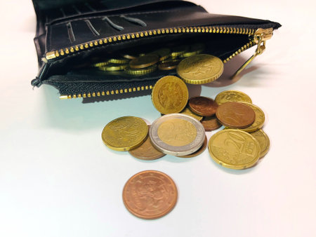 Euro coins in a black purse on a white background, close-upの写真素材