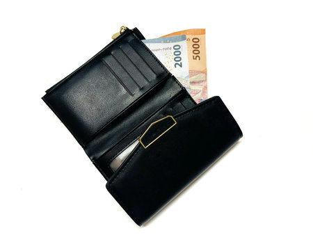 Black leather woman wallet with rupiah banknotes isolated on a white background.