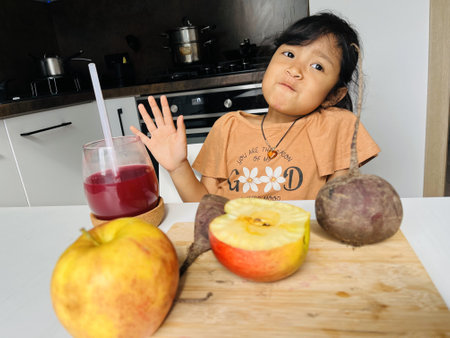 Cute little Asian girl refused to drink juice. Fruits in the kitchen. Healthy lifestyle conceptの写真素材