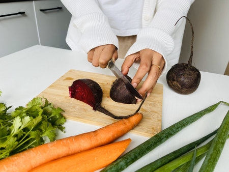 Woman cutting beetroot. Cutting healthy vegetables in the kitchen. Healthy eating and dieting concept.の写真素材