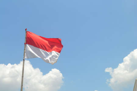 Indonesian Flag, Red and White, with blue sky background, hero day (Hari Pahlawan)の写真素材