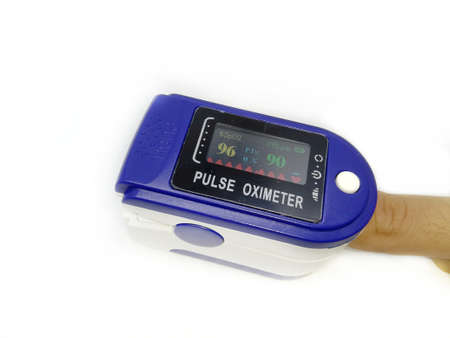 Woman using fingertip pulse oximeter on light blue background, top viewの写真素材
