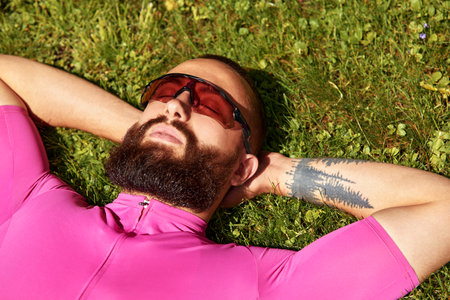 Young handsome cyclist is resting after a bike ride in the park