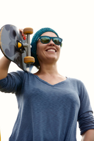 young happy woman with skateboard on the streetの写真素材