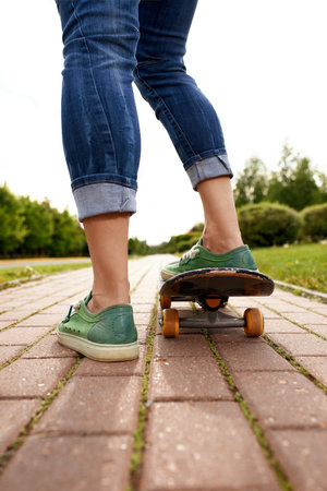 Girl with skateboard outdoors back viewの写真素材