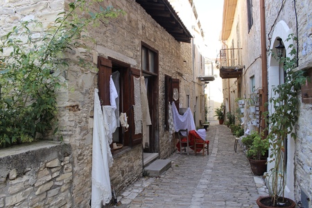 Narrow street in Larnaca. Narrow walking road between traditional stone houses in Cyprus with lace hanging outside.の写真素材