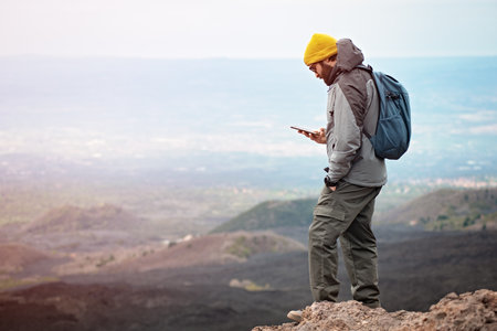 Hiker with backpack and mobile phone on top of the mountain.の写真素材