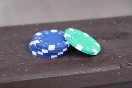 Blue, green jettons for hazard games on the brown board. Waiting for game.の写真素材