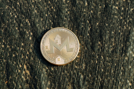 A golden metal monero coin who is using as crypt for paying and trading on stock exchange