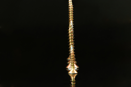 A many silver and golden nails put together in ascending order on black background. View from foreground.の写真素材
