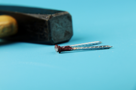 A detail on two rust nail ready for nailing nails on the wall or wooden board. Also we can see black...
