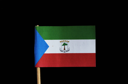 A official flag of Equatorial Guinea on toothpick on black background. Equatorial Guinea is located in central africa. The flag is created four colour and coat of arms. Blue, red, green, white.の写真素材