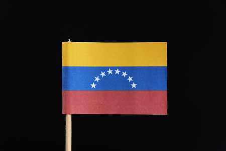 A official and original flag of Venezuela  on toothpick on black background. A horizontal tricolor of yellow, blue and red with an arc of eight white five pointed stars centered on the blue band.の写真素材