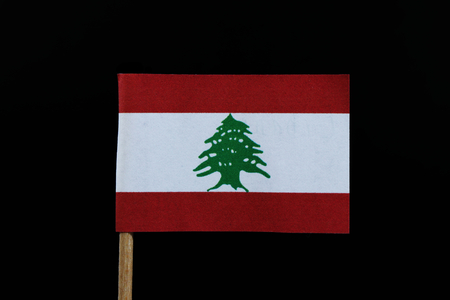 A official flag of Lebanon on toothpick on black background. Consists of a horizontal triband of red, white and red. charged with a green Lebanon Cedarの写真素材