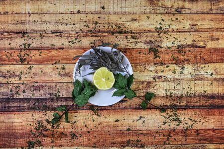 Typical herbal plants to kept healthy throughout the cold autumn. Sour lemon, green mint and salvia leaves and nettle around it. Concept of modern apothecary and knowing old herbalists.の写真素材