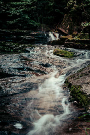 Small river in a dark forest is looking for a way through a rock. The rainy season in the Jizera Mountains on the land with Poland. Czech nature treasure. Europe beautiful places.の写真素材