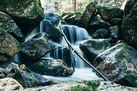 Slowly flowing stream and waterfalls in Jizera Mountains, Czech Republic. Water flows from all cracks of stones and rocks. Source of drinking water.の写真素材