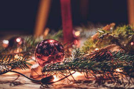 Red shimmering bank with spruce twigs and a beautiful warm light creates the true essence of...