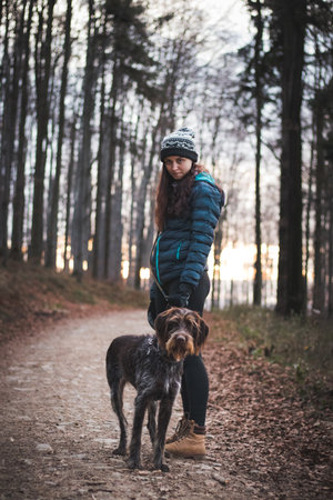 Fascinated face of brown female Bohemian Wire-haired Pointing Griffon. Owner in winter clothes with slight smile. Concept of relationship between man and dog. Medium Slate Blue and lightviolet tones.の写真素材