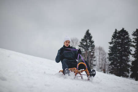 Teenager caught riding on a wooden sledge trying to adjust his direction with his hand and...