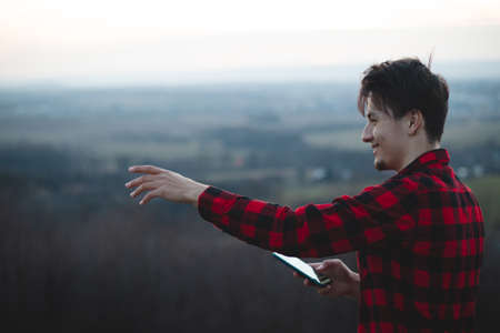 portrait of a twenty-three year old man in a black and red checked shirt, smiling at his friend with his real smile without any pretence. The authentic mood of a young man on an indecisive journey.の写真素材