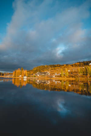 Autumn sunset at Lake Syvajarvi, in Hyrynsalmi, Finland. Reflection of red-orange petals on the lake surface. Storm clouds at sunset. Autumn vibes.の写真素材