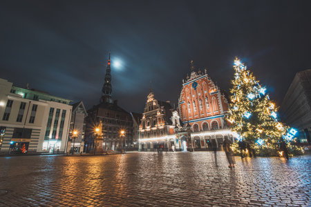 18.12.2021 - Riga. Christmas decoration on Ratslaukums Square in the middle of the historical part of Riga, the capital of Latvia. Long exposure capturing Christmas tree, the town hall and full moon.のeditorial素材