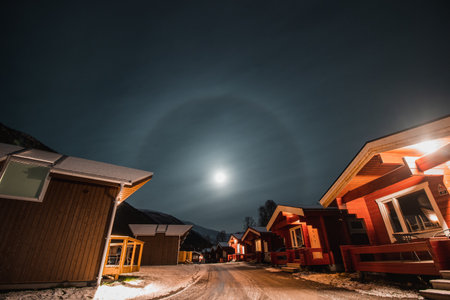 The halo effect of the moon in the northern Norwegian city of Tromso among the red typical huts. A moon sighting. far beyond the Arctic Circle.の写真素材