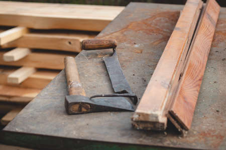Traditional woodworking using old and hand tools such as an ax and planer stored on an iron table...