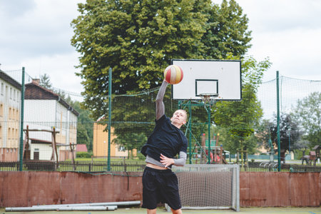 Player is serving on a hard court during an outdoor game. The action showcases athleticism, agility, and control in a dynamic setting.の写真素材