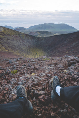 Volcanic landscapes of the Snaefellsnes Peninsula in Iceland, with vast craters, rugged terrain, and distant green mountains under a cloudy sky.の写真素材