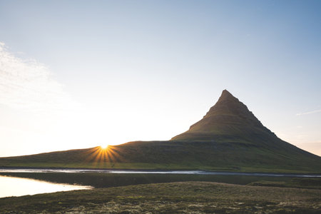 Kirkjufell mountain on the Snaefellsnes peninsula in Iceland during sunset. The iconic peak reflects...