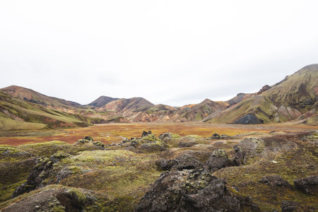 Iceland rainbow mountains in Landmannalaugar glow with surreal colors of volcanic rhyolite, moss,...