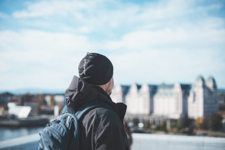 Traveler stands on Oslo Opera House, gazing at the city skyline under a blue skyâurban discovery wrapped in crisp Nordic air. Capital city of Norway.の写真素材