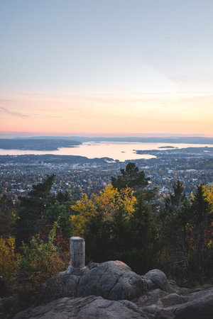 Sunset from Vettakolltoppen paints Oslofjord in soft pastels, offering a serene panorama above the cityâan unforgettable moment of Norwegian autumn tranquility.の写真素材