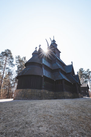 Morning sunlight shines through the towers of Gol Stave Church in Oslo, Norway, revealing the intricate wooden design of ancient Nordic architecture.の写真素材