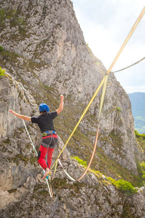 Young slackliner man balancing on a slackline betweend two rocks. Highline with a beautiful natural...