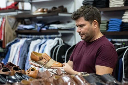 Man looking at shirts, jackets and shoes to try on at a fashion store