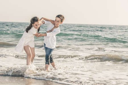 boy and girl playing on the seashoreの写真素材