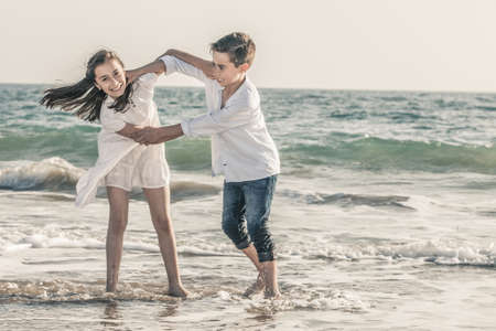 boy and girl playing on the seashoreの写真素材