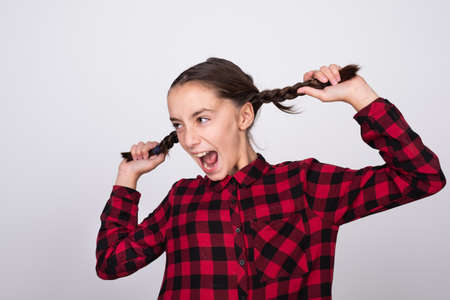 Excited girl pulling her hairs, she has two tailsの写真素材
