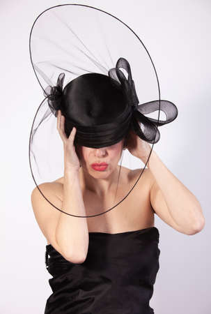 beautiful woman holding on black hat, retro fashionの写真素材