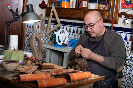 craftsman working the leather in his small workshop