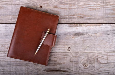businessman's agenda and pen on wooden backgroundの写真素材