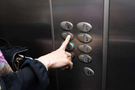woman inside an elevator pressing a button