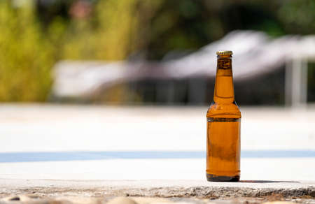bottle of beer on the edge of a swimming poolの写真素材