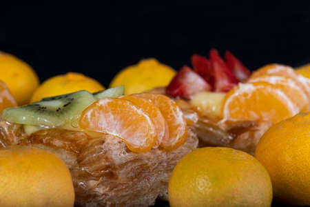 puff pastry with tangerine fruit on black backgroundの写真素材