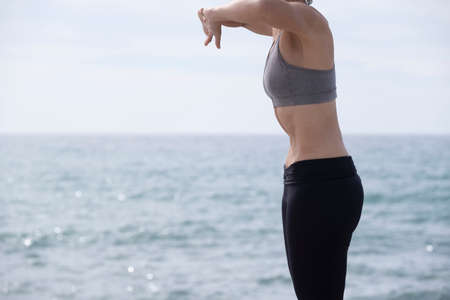 woman doing hypopressive exercise in the seaの写真素材