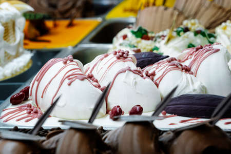 Strawberry cream ice cream in a display case with different ice cream tubsの写真素材